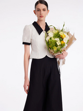 a lady in v-neck jacquard top and black skirt